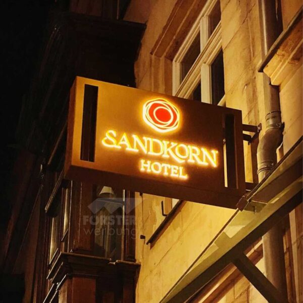 Leuchtendes Hotelschild Sandkorn bei Nacht