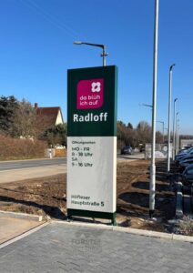 Firmenschild mit Öffnungszeiten und Adresse in Deutschland